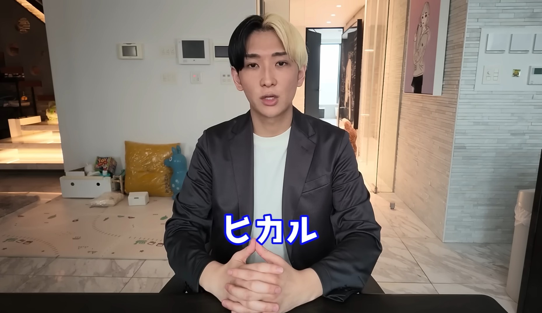 Hikaru speaking to camera at a table in a bright home interior, with his name shown in Japanese.